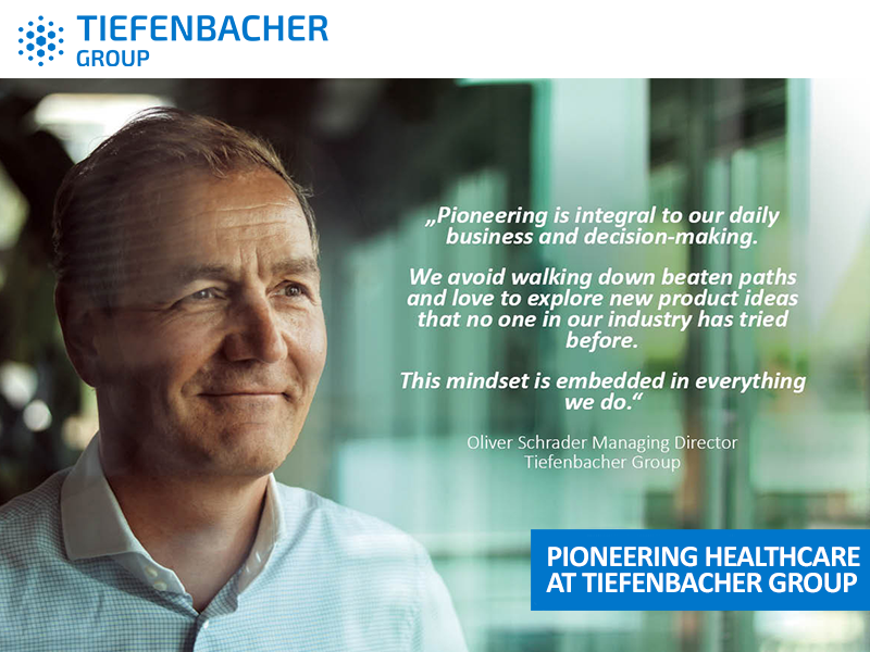 Tiefenbacher Group - A man in a blue shirt stands by a window, softly smiling. A quote about pioneering pharmaceutical healthcare solutions is displayed beside him, along with the Tiefenbacher Group logo and the caption "Pioneering Healthcare at Tiefenbacher Group.